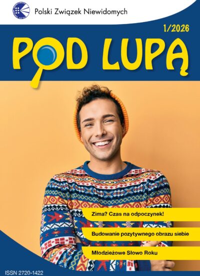 Uśmiechnięty młody mężczyzna w pomarańczowej czapce i wesołym, kolorowym swetrze w pasy. Na każdym pasie jest inny wzór, najczęściej geometryczny. Całość w stylu norweskim.