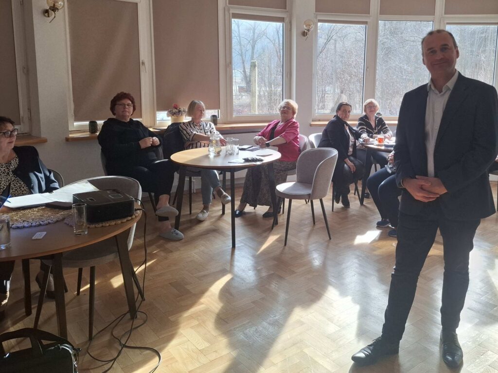 Uczestnicy szkolenia przy stolikach.