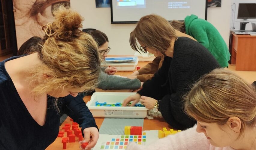 Uczestnicy szkolenia układają klocki LEGO BRAILLE BRICKS.