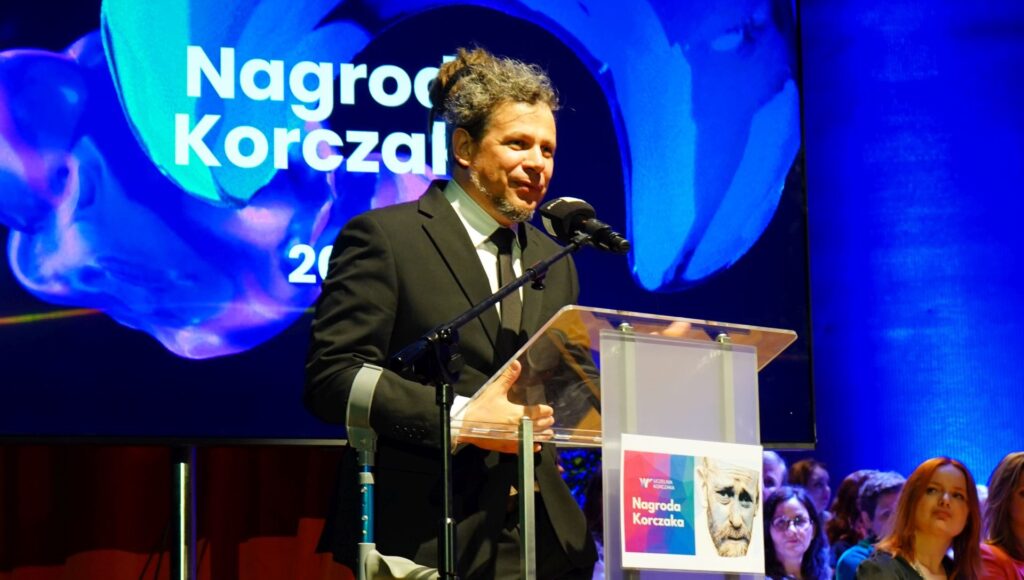 Łukasz Szeliga przemawia na scenie po otrzymaniu nagrody.