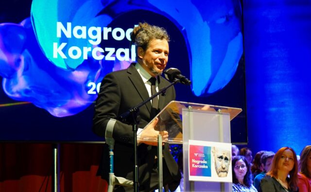 Łukasz Szeliga przemawia na scenie po otrzymaniu nagrody.