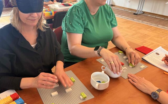 Uczestniczki warsztatów układają klocki LEGO BRAILLE BRICKS.