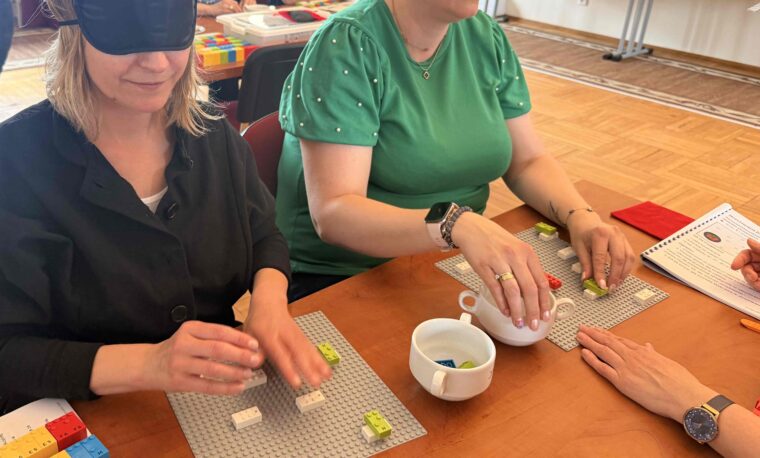 Uczestniczki warsztatów układają klocki LEGO BRAILLE BRICKS.