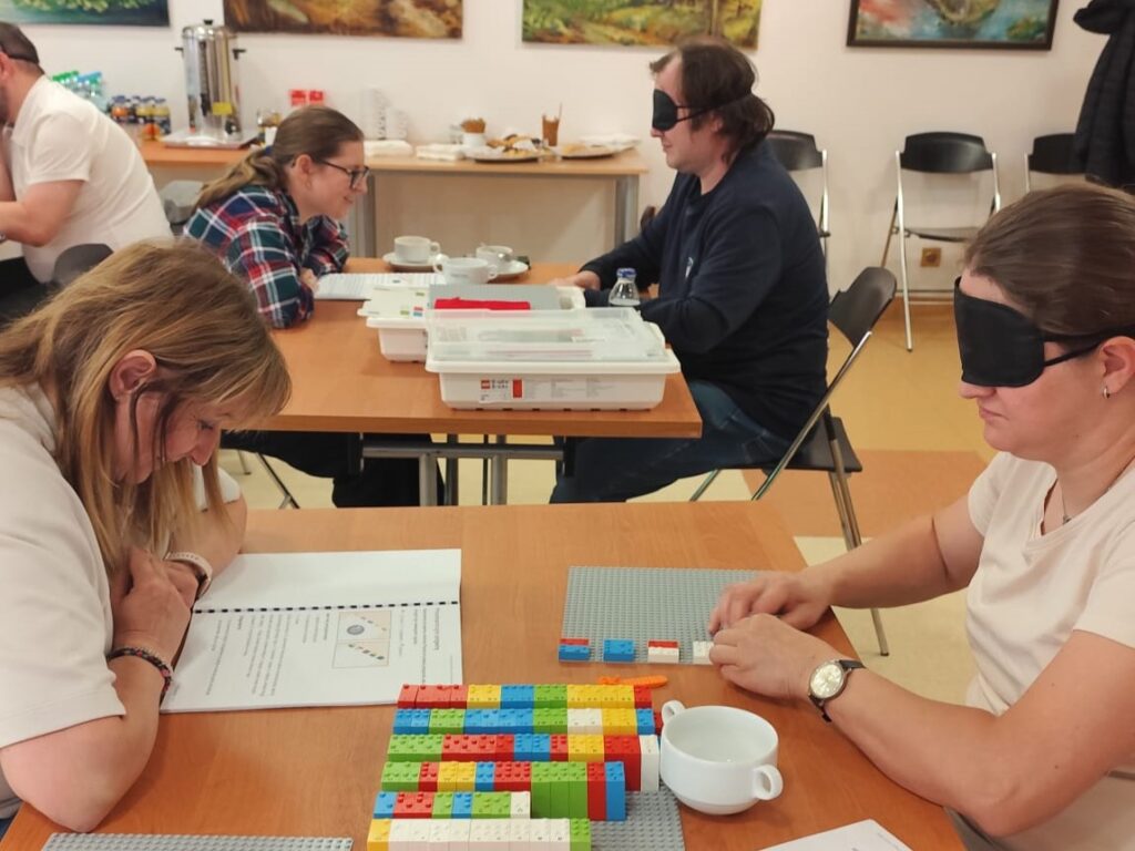 Uczestnicy warsztatów uczą się metodyki LEGO BRAILLE BRICKS.