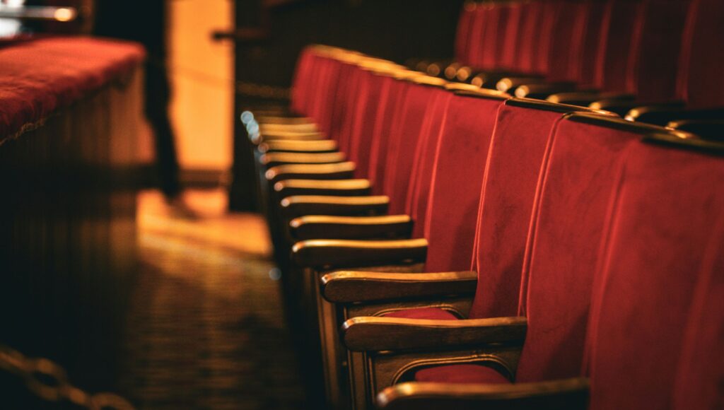 Na zdjęciu czerwone siedzenia widowni teatralnej.