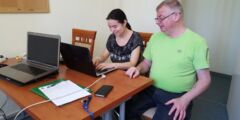 Instruktor i uczestniczka zajęć komputerowych siedzą przy komputerze.