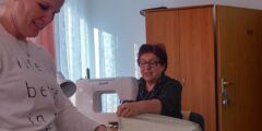 Dwie pracownice ośrodka w Muszynie przy pracy. Jedna szyje przy użyciu maszyny do szycia, druga ręcznie.