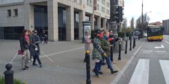 Uczestnik szkolenia z zasłoniętymi oczami i z białą laską przechodzi przez przejście dla pieszych