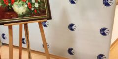 Obraz na sztaludze. Tuż za nim ścianka z logotypami PZN.